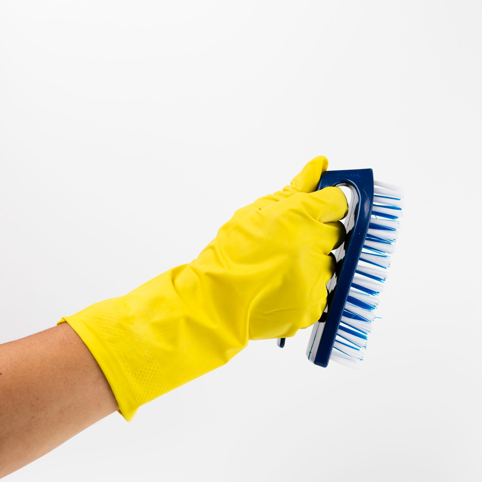 close up hand with yellow glove brush